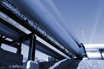 Image showing industrial pipelines on pipe-bridge against blue sky