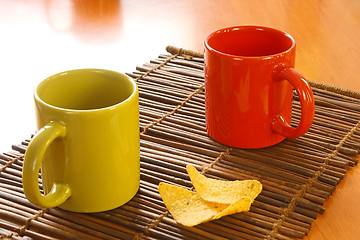 Image showing Red mug and chips on glass plate