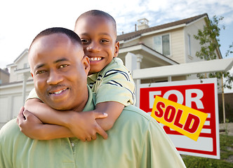 Image showing Father and Son In Front of Real Estate Sign and Home