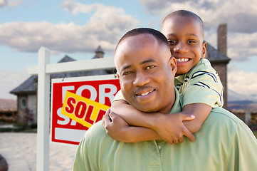 Image showing Father and Son In Front of Real Estate Sign and Home