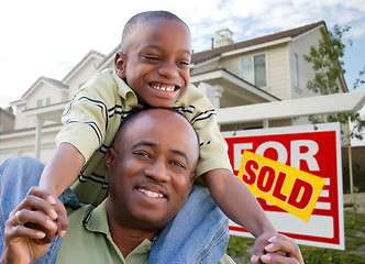 Image showing Father and Son In Front of Real Estate Sign and Home