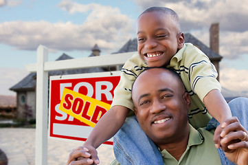 Image showing Father and Son In Front of Real Estate Sign and Home