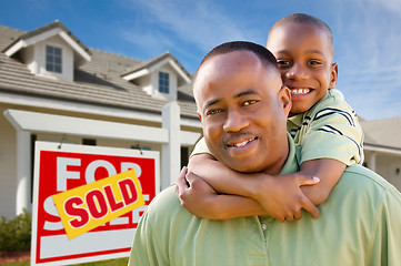 Image showing Father with Son In Front of Real Estate Sign and Home