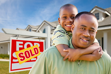 Image showing Father with Son In Front of Real Estate Sign and Home