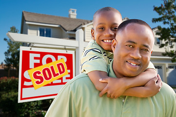 Image showing Father and Son In Front of Real Estate Sign and Home