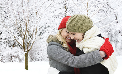 Image showing Two girl friends hugging outside in winter