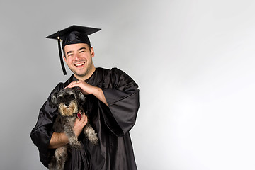 Image showing Graduate Holding Dog