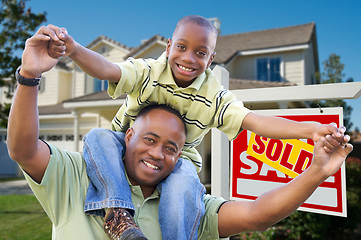 Image showing Father and Son In Front of Real Estate Sign and Home