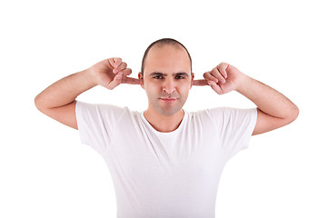 Image showing Young man, holding fingers in his ears, protecting himself from noise