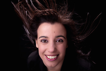 Image showing young woman from the front, with her hair in the wind