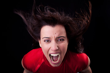 Image showing beautiful young woman with her hair in the wind, screaming in fury