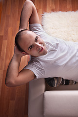 Image showing Happy man lying relaxed on the couch