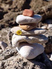 Image showing Stone tower with yellow flower