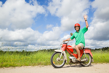 Image showing Happy man driving a moped