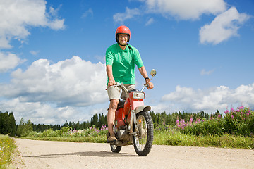 Image showing Happy man driving a moped