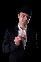 Image showing  young man with a black hat and a glass of whiskey in his hand