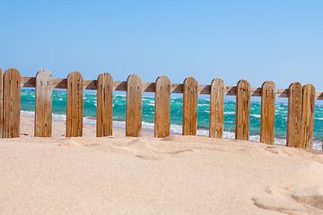 Image showing Small wood fence in sand on the coast