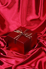 Image showing gift box on red satin background