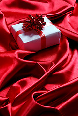 Image showing gift box on red satin background