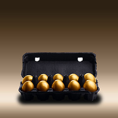 Image showing Gold eggs in a black carton