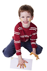 Image showing Children playing with paint, stamping his hand on a white sheet