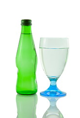 Image showing Bottle and glass of mineral water reflected on white background