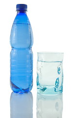 Image showing Bottle and glass of mineral water reflected on white background