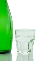 Image showing Bottle and glass of mineral water reflected on white background