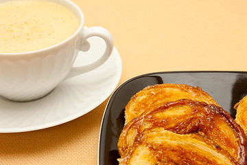 Image showing Closeup of coffee with milk in white cup and a palmier pastry