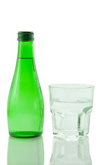 Image showing Bottle and glass of mineral water reflected on white background