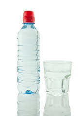 Image showing Bottle and glass of mineral water reflected on white background