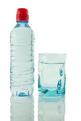 Image showing Bottle and glass of mineral water reflected on white background