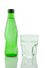 Image showing Bottle and glass of mineral water reflected on white background