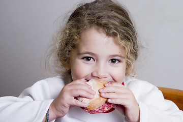 Image showing cute little girl eating a sandwich