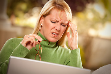 Image showing Grimacing Woman Using laptop Suffering a Headache