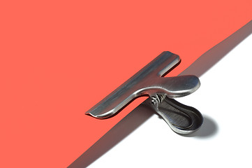 Image showing Metallic paperclip on red paper