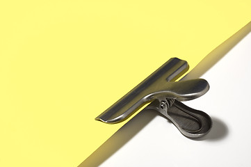 Image showing Metallic paperclip on yellow paper