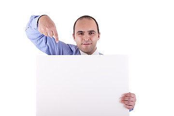 Image showing Young businessman holding a whiteboard and pointing, looking at the camera