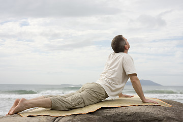 Image showing Mature man doing yoga at the sea