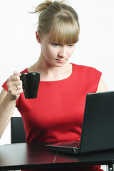 Image showing Businesswoman with black cup looking to monitor
