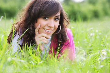 Image showing Brunette in white laying in grass