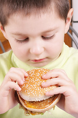 Image showing Boy looking at hamburger