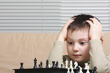 Image showing Little chess player embracing head