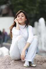 Image showing Woman in casual sitting on stone