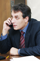 Image showing Businessman at desk talking on phone