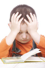 Image showing Pensive kid reading book