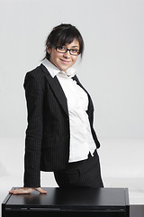 Image showing Smiling businesswoman leaning on desk