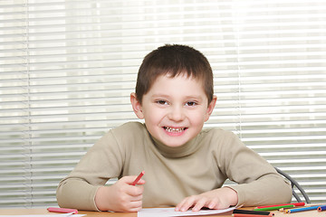 Image showing Smiling boy with red pencil