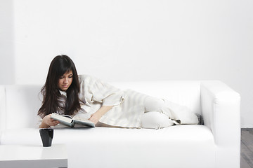 Image showing Brunette reading on sofa