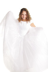 Image showing Smiling bride raising dress edges